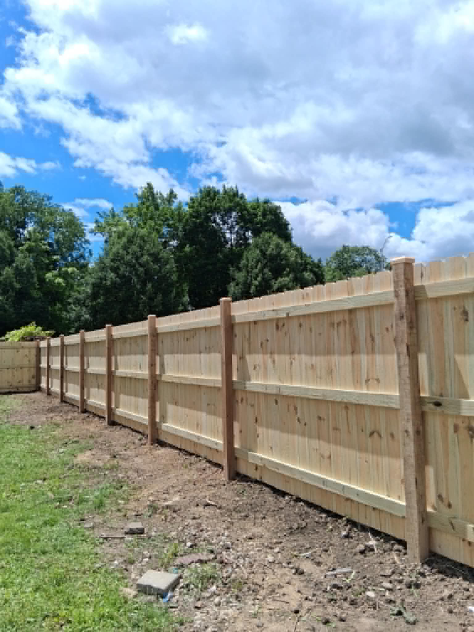 Long newly installed wooden backyard privacy fence